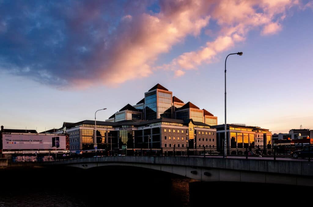 Commercial property buildings at sunset, viewed from a riverside bridge, representing commercial real estate investment in the Midlands